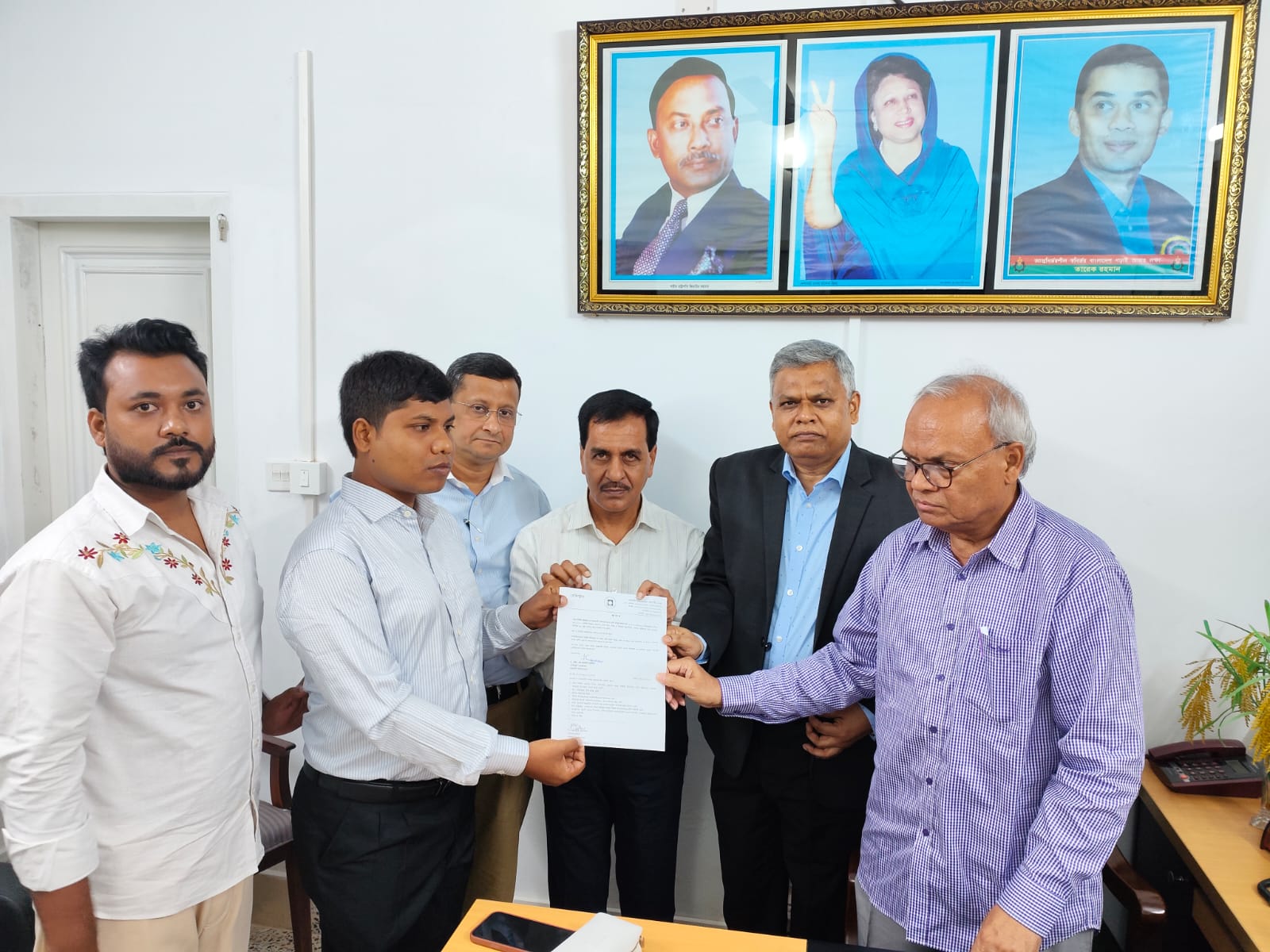 রাজশাহী বিশ্ববিদ্যালয়ে কর্মকর্তা হিসেবে নিয়োগপত্র গ্রহণ করছেন দৃষ্টিহীন শাকিল হোসেন